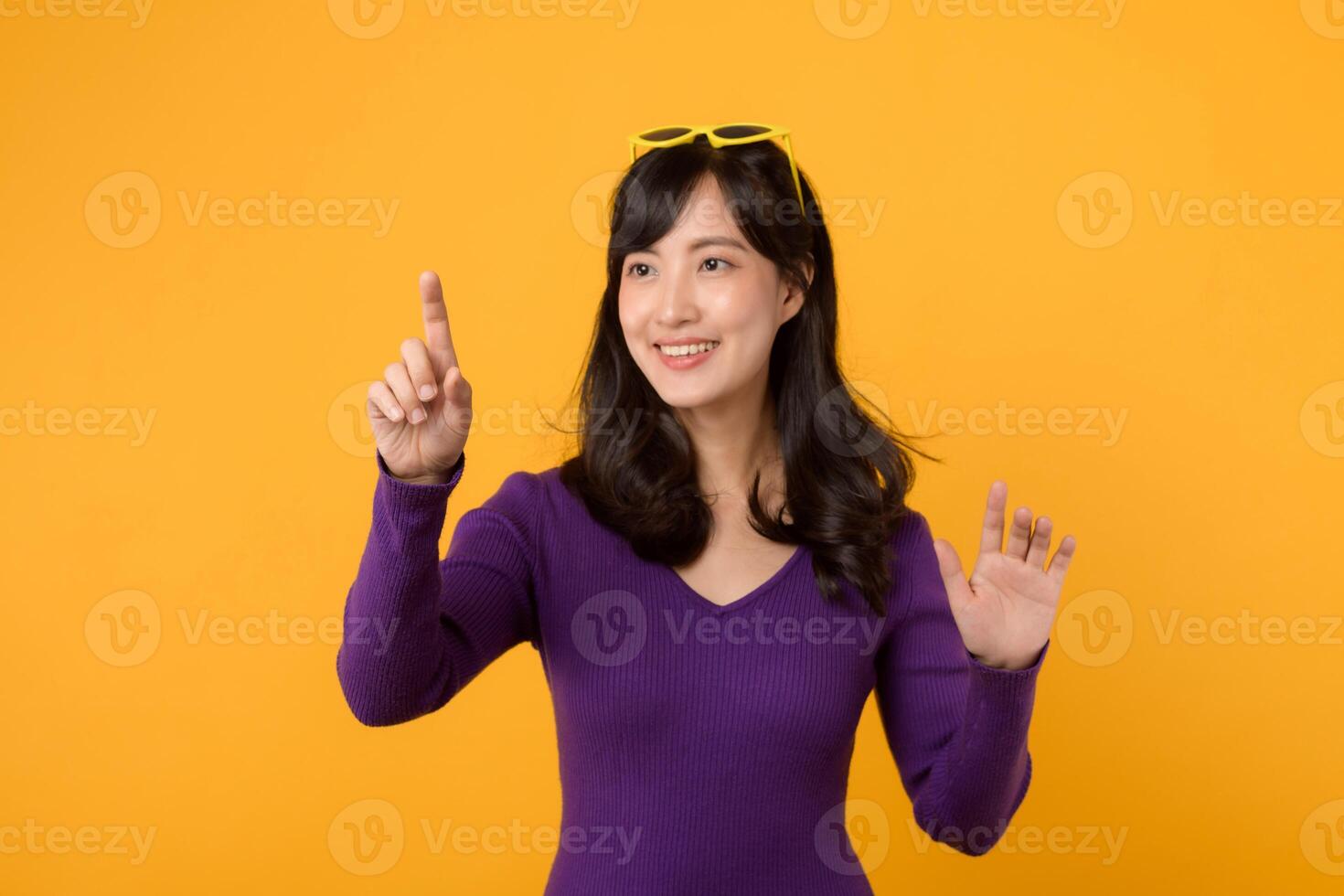 ung asiatisk 30s affärskvinna bär lila hoppare skjorta pekande på osynlig skärm. foto