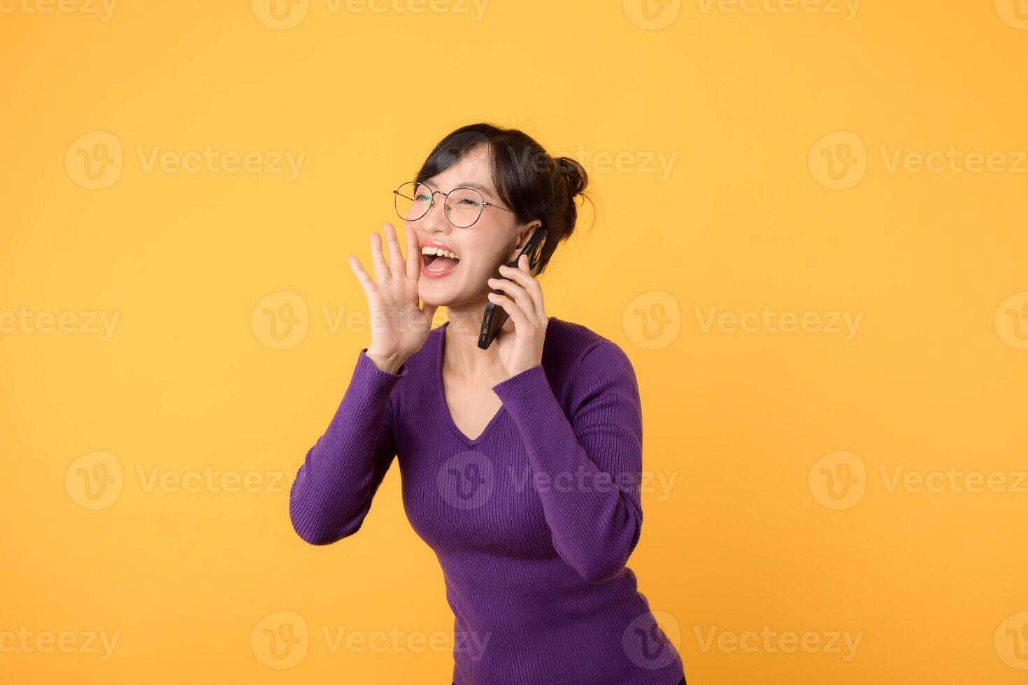 ansluta, affär, och lyckas uppkopplad med glad lady, bär en lila skjorta och glasögon, och henne smartphone. omfamning de skönhet av digital kommunikation mot en gul bakgrund foto
