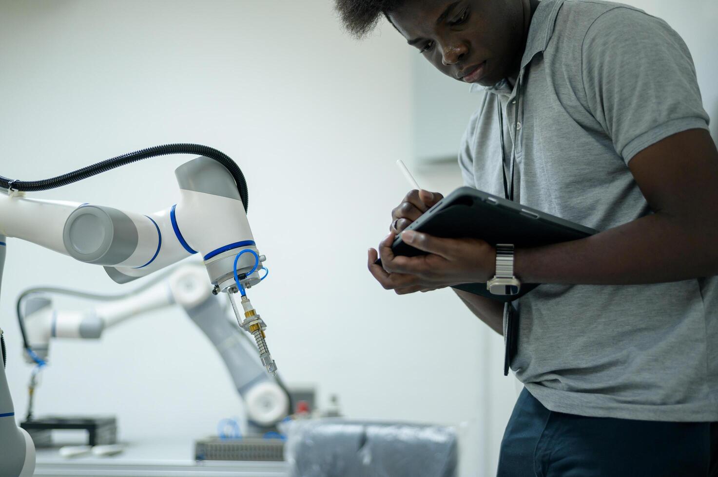 praktikant robotik ingenjör inlärning med programmering och manipulera robot hand, industriell robotik design, hög tech anläggningen, modern maskin inlärning. massa produktion automatik. foto