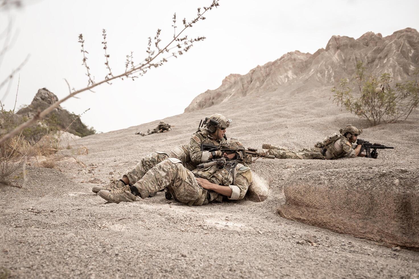 soldater i kamouflage uniformer siktar med deras gevär redo till brand under militär drift i de öken- soldater Träning i en militär drift foto