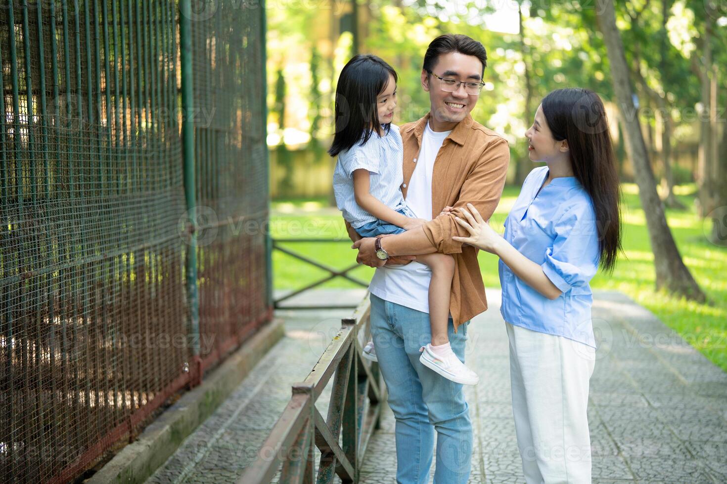 Foto av ung asiatisk familj på parkera