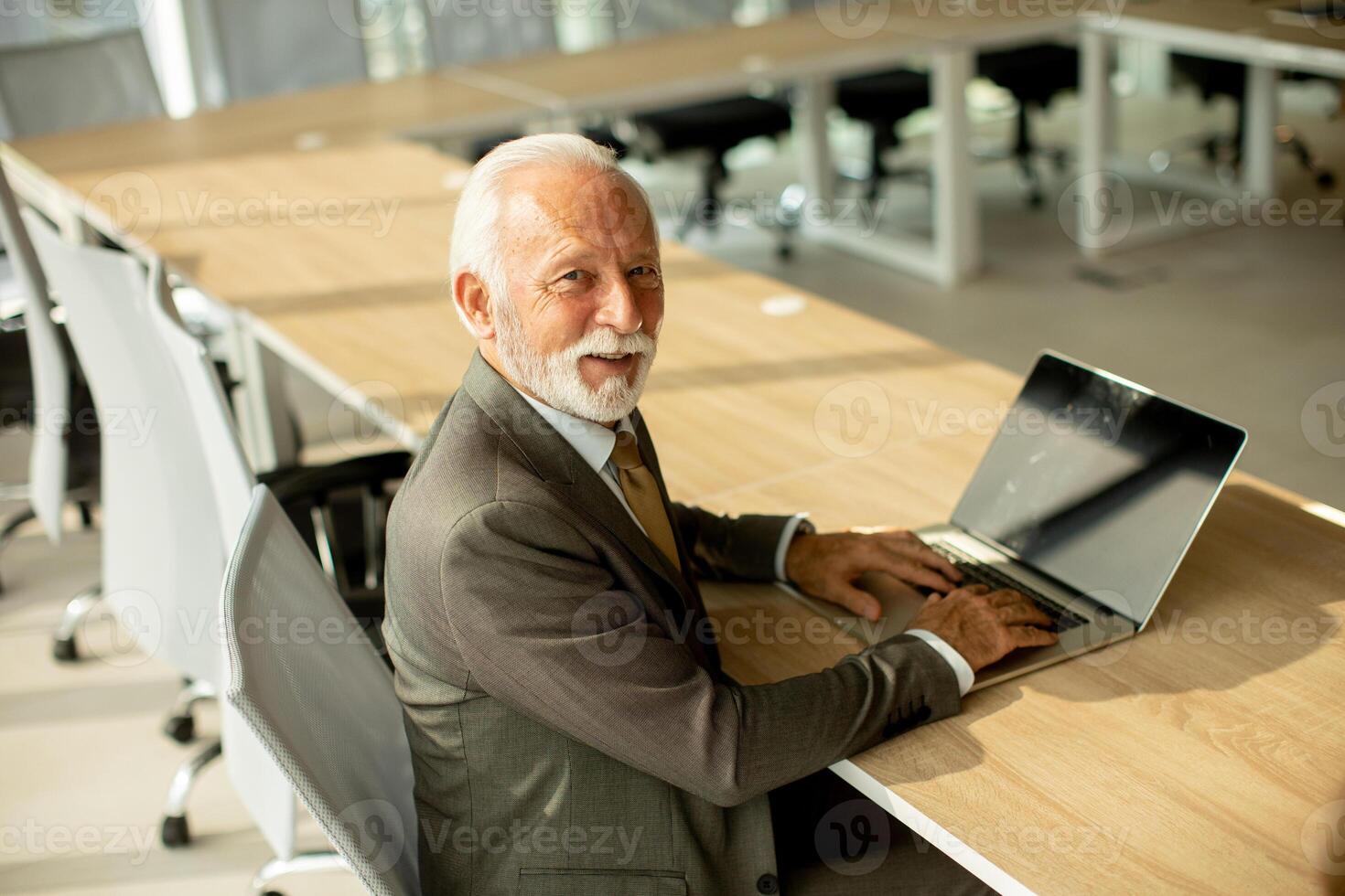 senior affärsman arbetssätt på bärbar dator dator i kontor foto