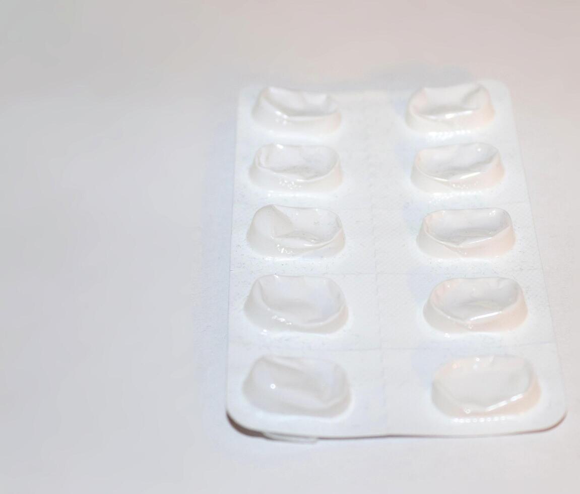 apotek apotek koncept. förpackningar av vita piller packade i blister med kopia utrymme isolerad på en vit bakgrund. fokus på förgrunden, mjuk bokeh. foto