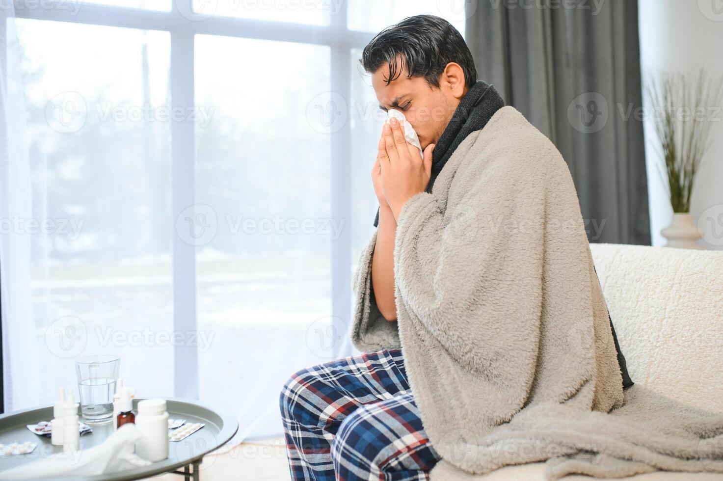hälsa, kall och människor begrepp - sjuk ung indisk man i filt har huvudvärk eller feber på Hem foto
