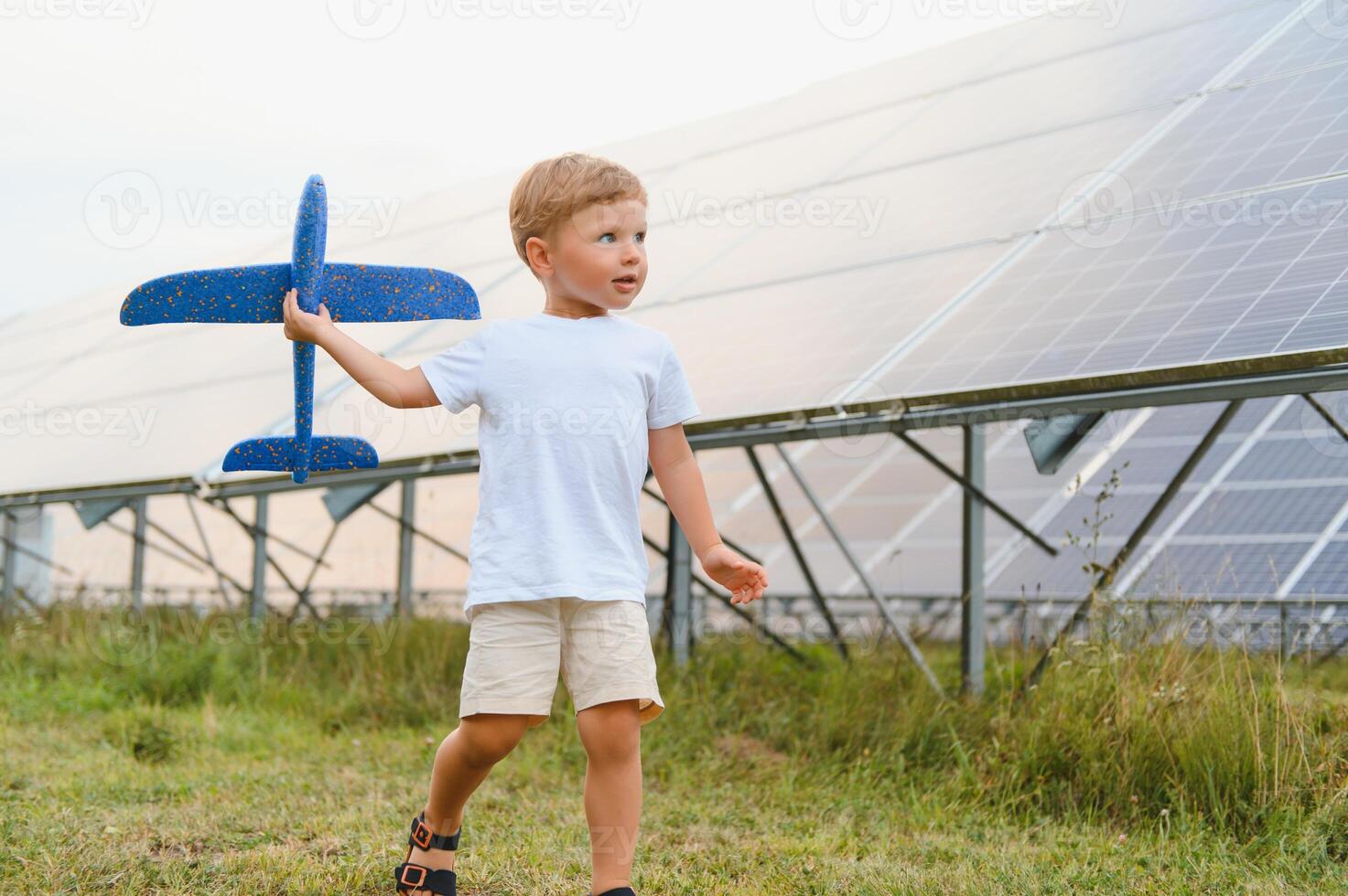 en liten pojke är har roligt nära de sol- paneler. de begrepp av sol- energi. foto