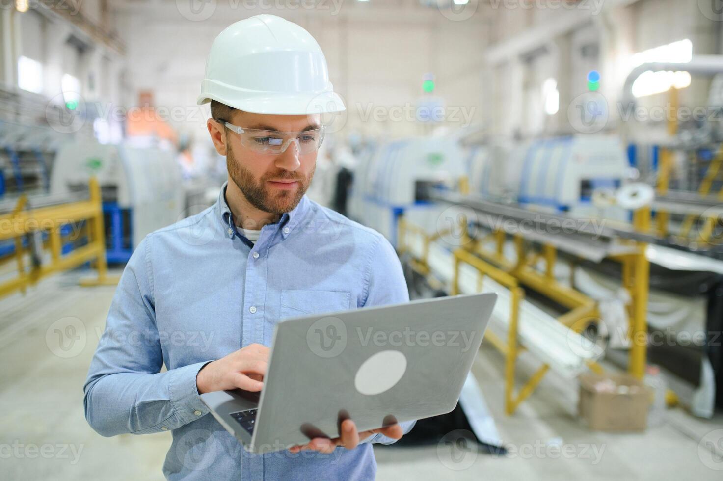 sida se av tekniker eller ingenjör med headsetet och bärbar dator stående i industriell fabrik foto