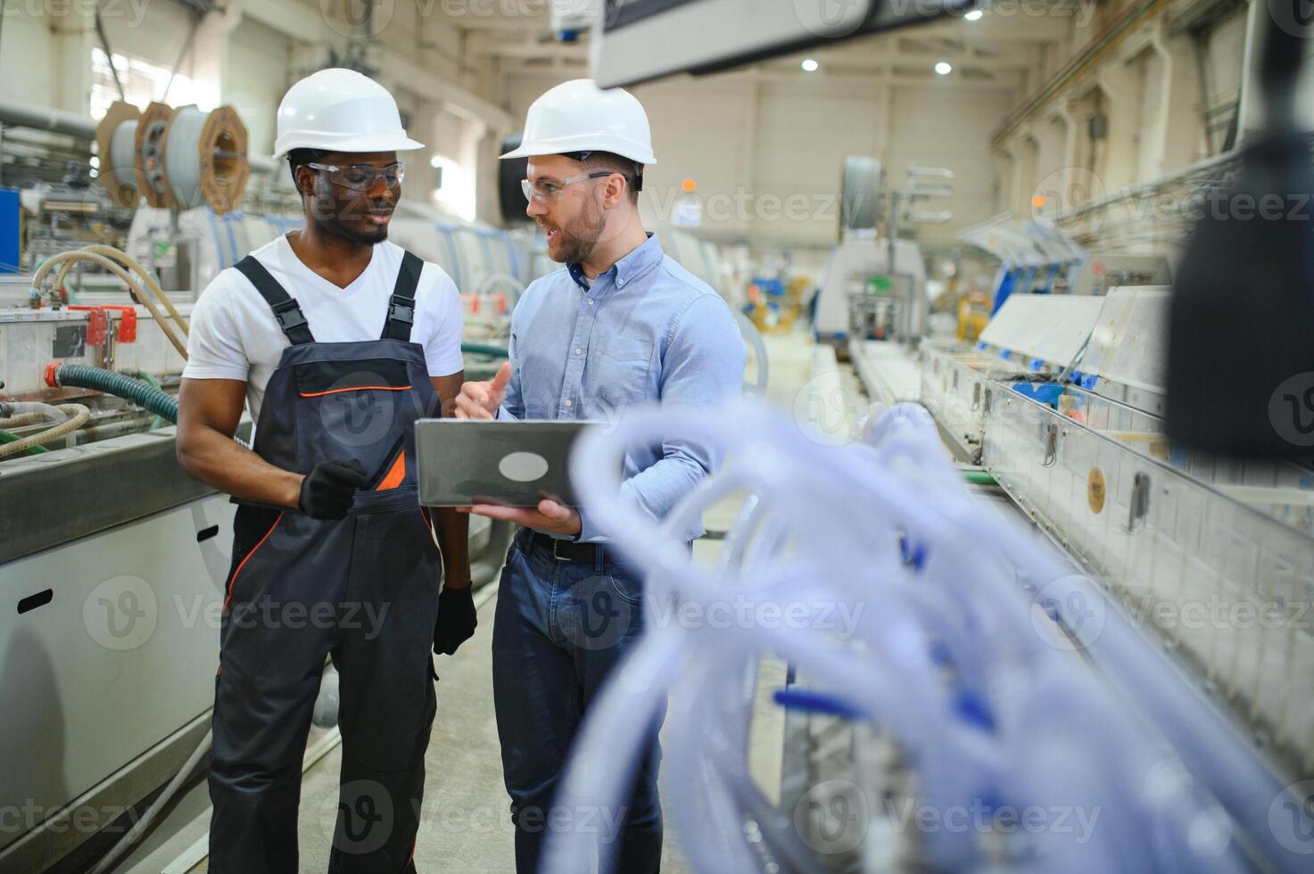 ett ingenjör kommunicerar med en arbetstagare på en produktion linje foto