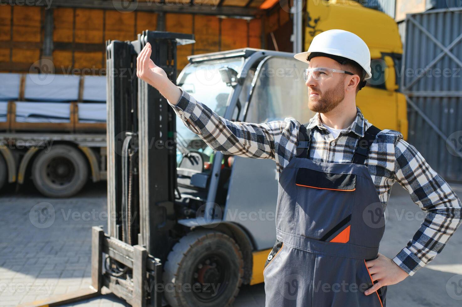 porträtt av professionell gaffeltruck förare i fabrikens lager foto