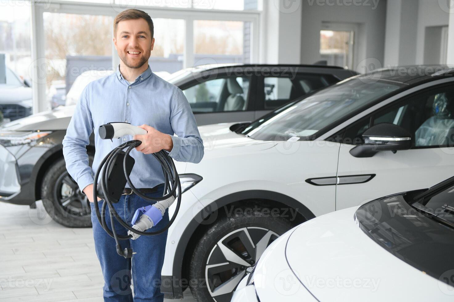 begrepp av uppköp elektrisk fordon. stilig företag man står nära elektrisk bil på återförsäljare foto