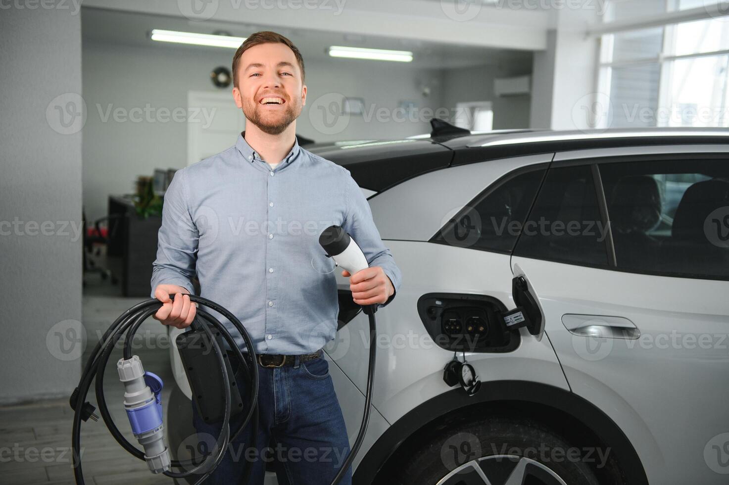 begrepp av uppköp elektrisk fordon. stilig företag man står nära elektrisk bil på återförsäljare foto