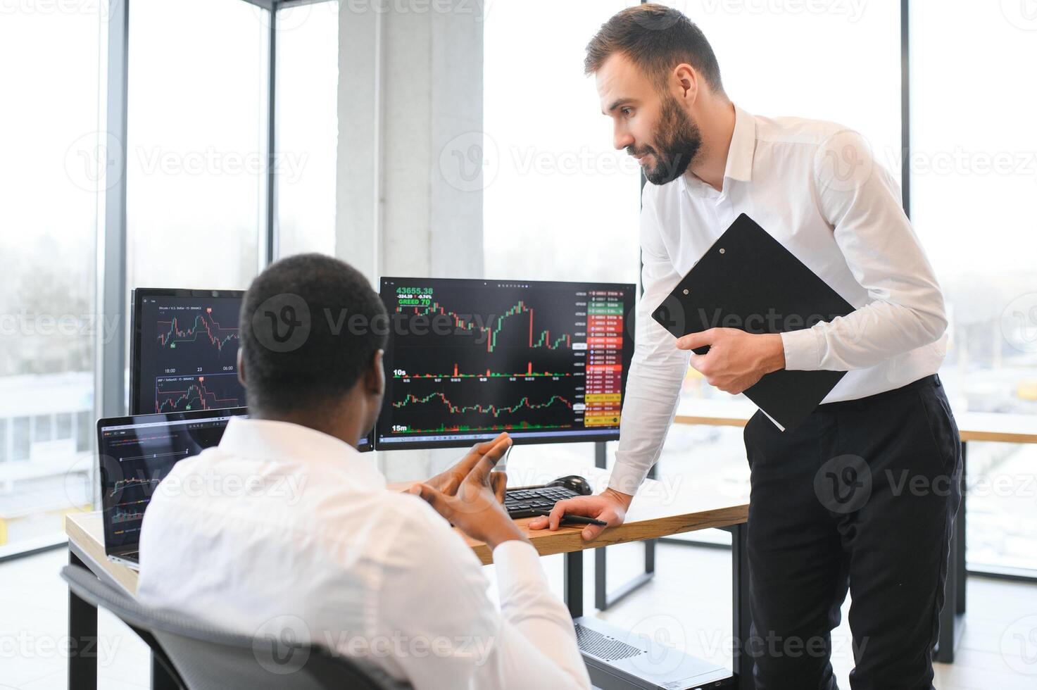 två män kollegor handlare Sammanträde på skrivbord på kontor övervakning stock marknadsföra foto