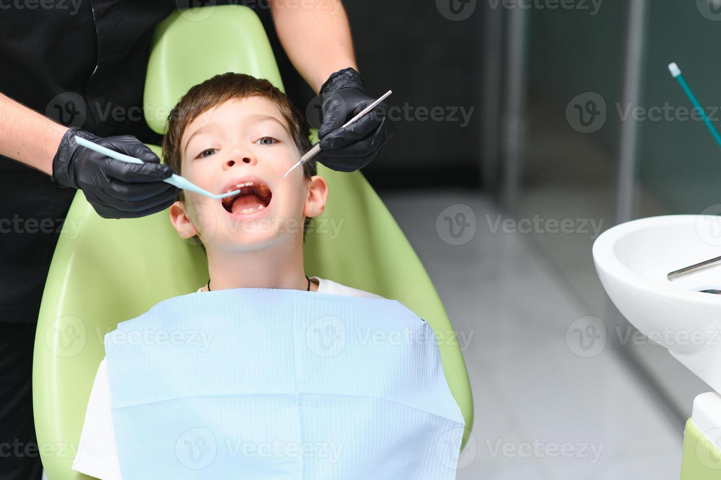 närbild av liten pojke öppning hans mun under dental kolla upp foto