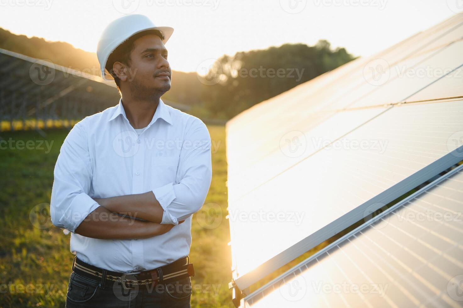 porträtt av ung indisk manlig ingenjör stående nära sol- paneler, med klar blå himmel bakgrund, förnybar och rena energi. skicklighet Indien, kopia Plats foto