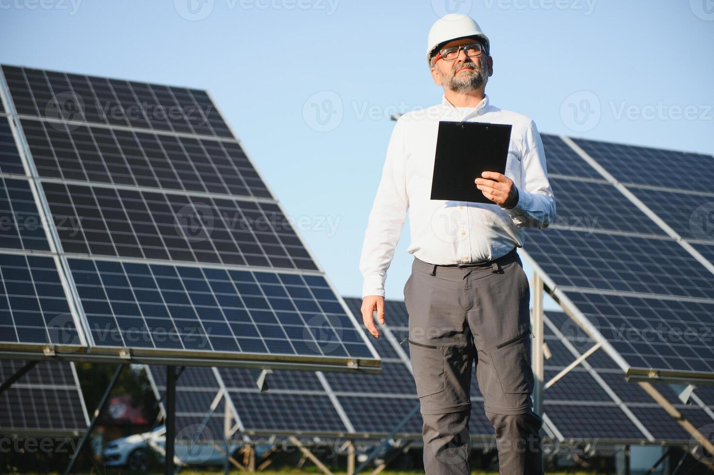 sol- kraft växt. man stående nära sol- paneler. förnybar energi foto