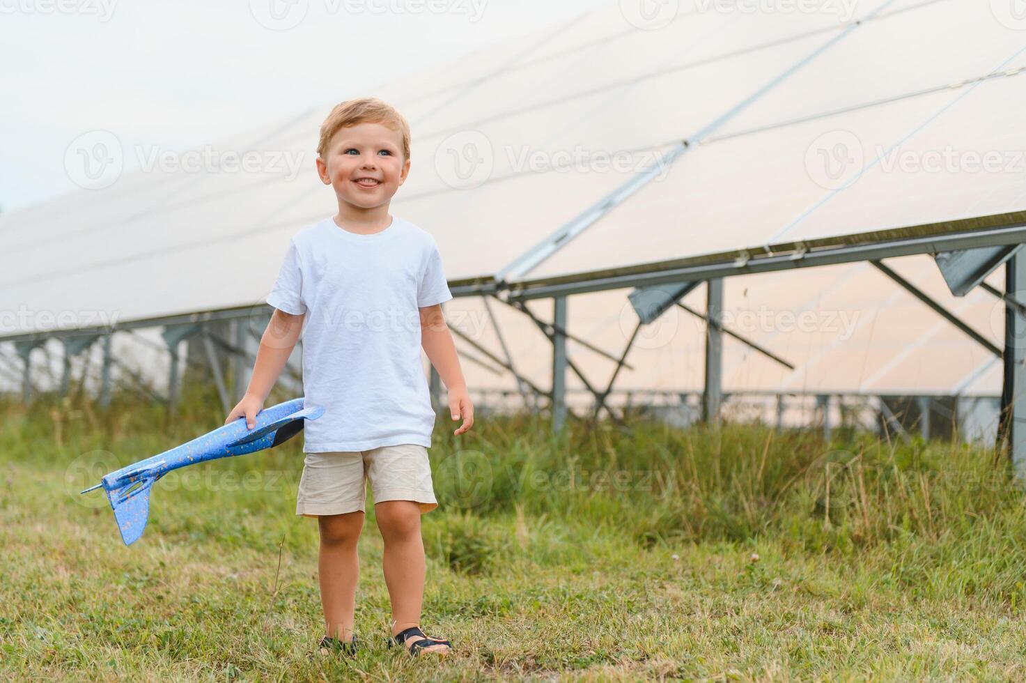 en liten pojke är har roligt nära de sol- paneler. de begrepp av sol- energi. foto