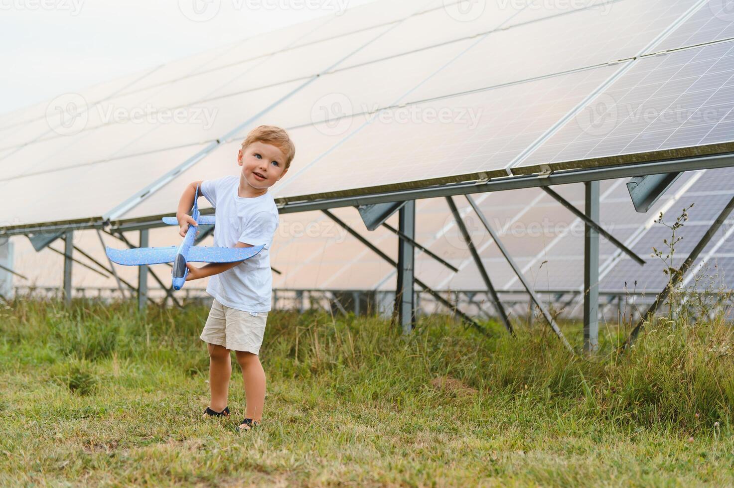 en liten pojke är har roligt nära de sol- paneler. de begrepp av sol- energi. foto