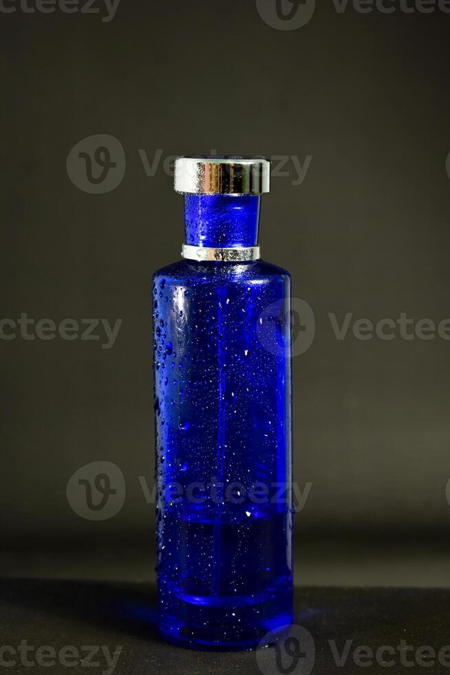transparent mörk blå flaska parfym isolerat svart bakgrund för falsk upp design foto