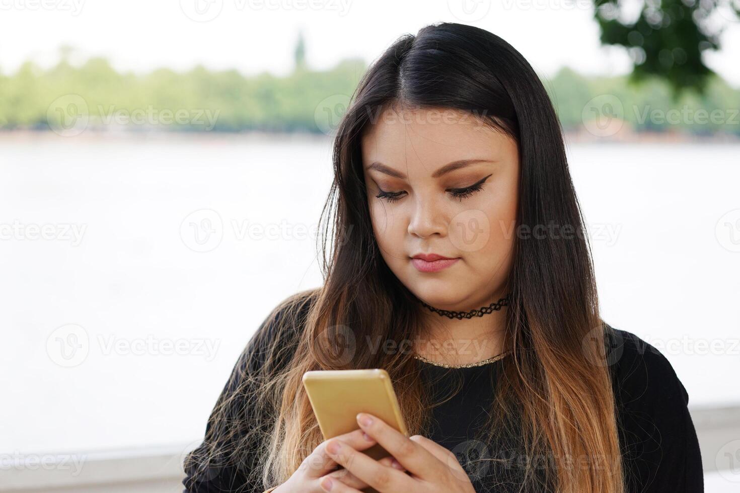 ung asiatisk kvinna kontroll henne smartphone foto