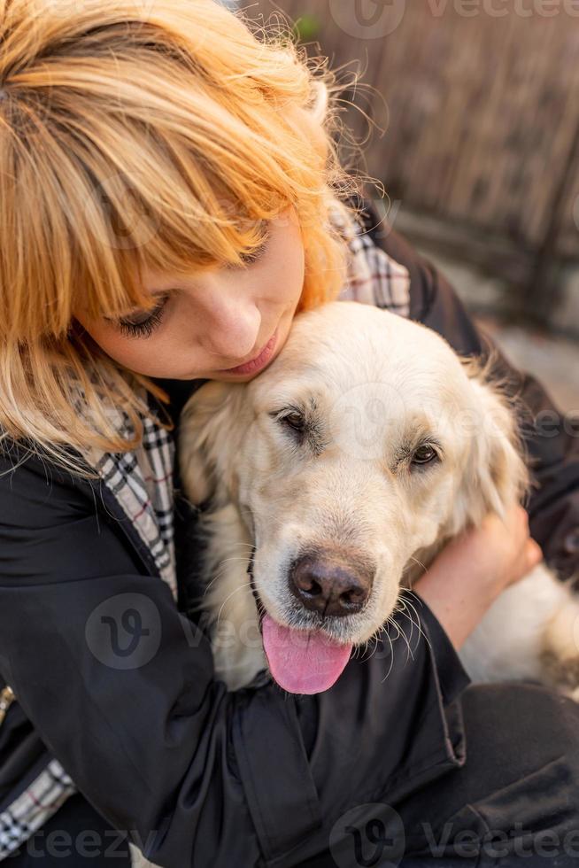 blond kvinna kramar sin retrieverhund foto