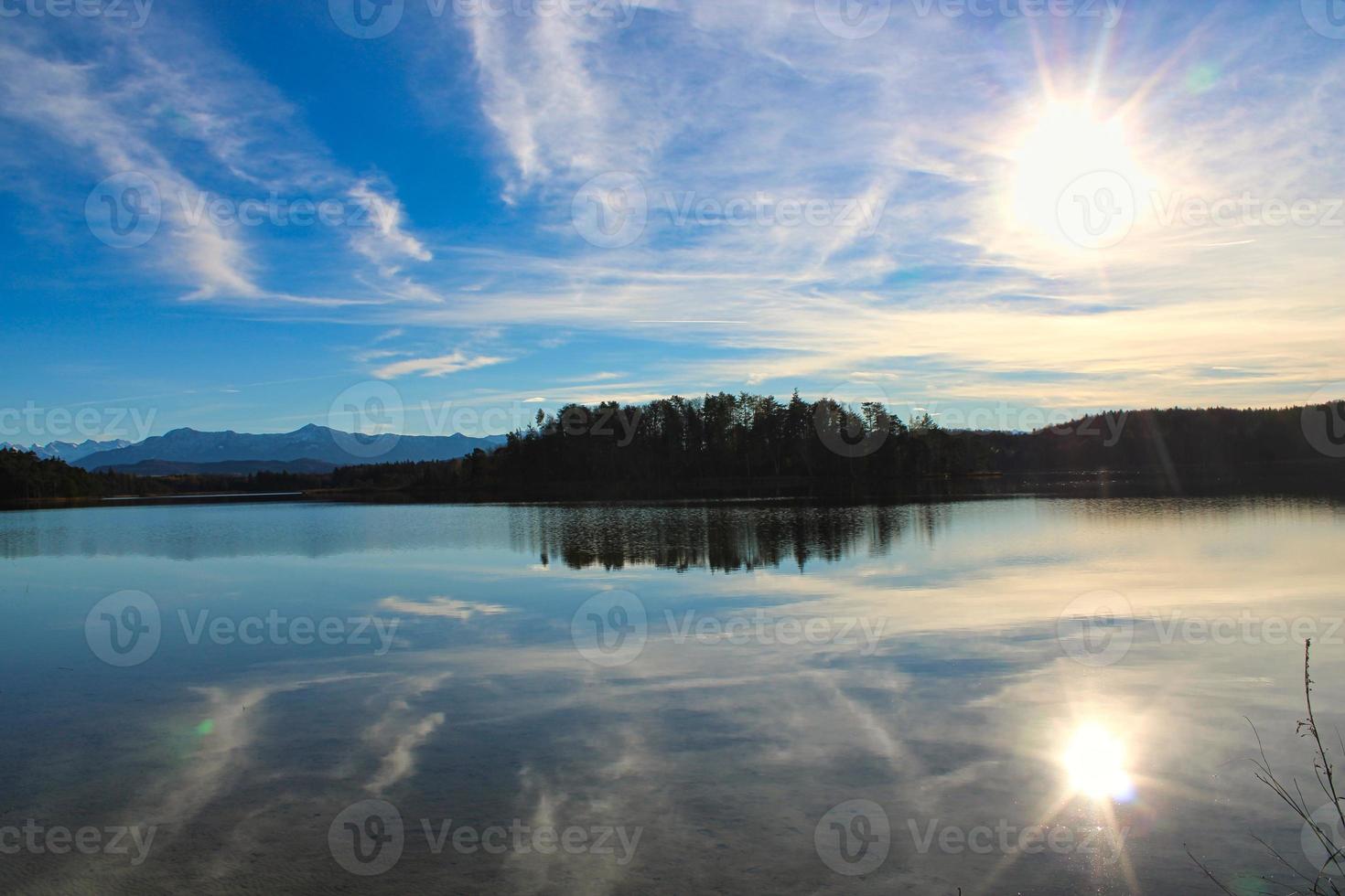 romantiskt foto av en sjö med perfekta solreflektioner på vattnet