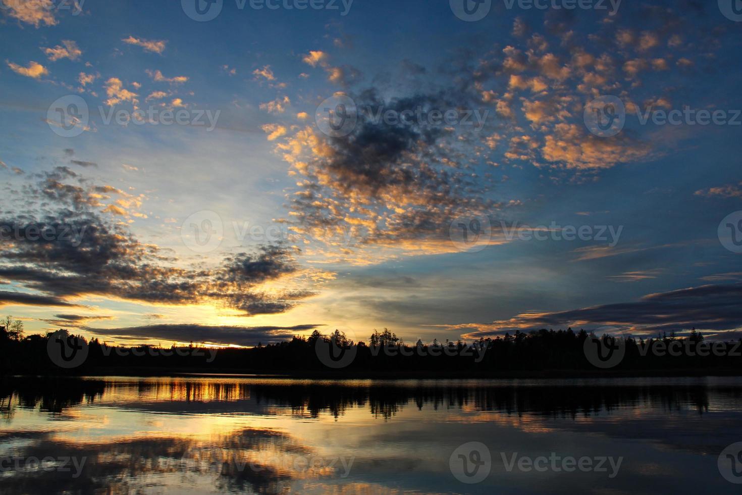 romantisk solnedgång med unika reflektioner över en fridfull sjö foto