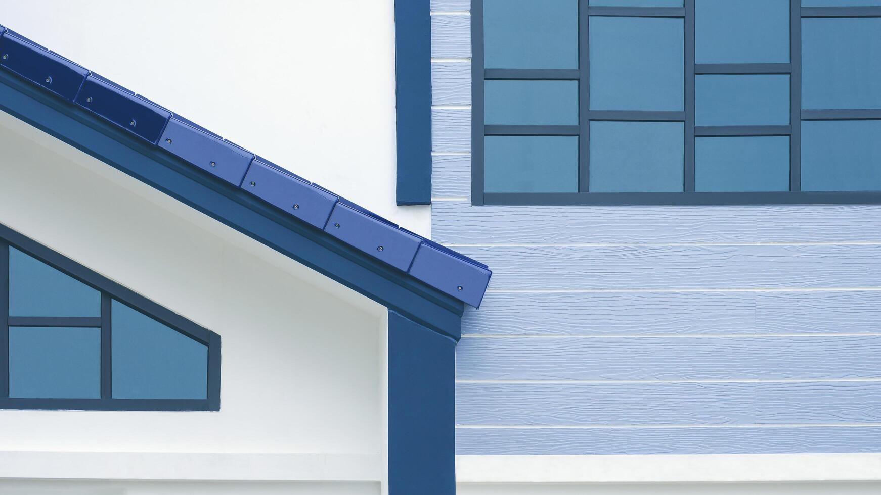 ljus reflexion på glas vinden fönster yta med del av markis bricka tak utanför av modern vit och blå hus byggnad foto