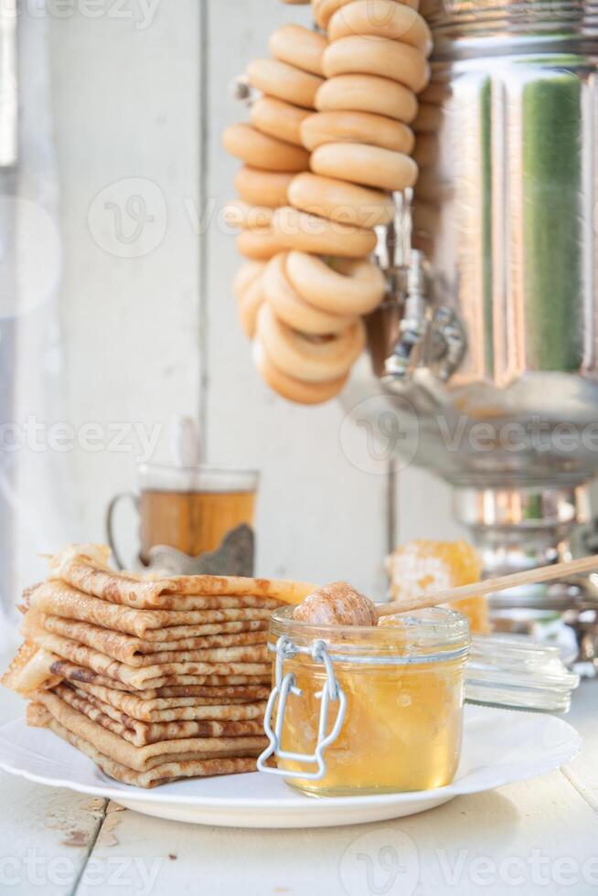 ryska pannkakor med honung och en kopp av te från en årgång samovar maslenitsa festival begrepp foto