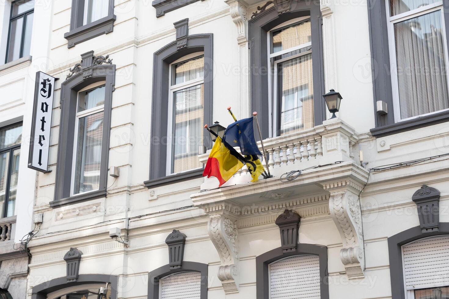 belgisk och europeisk flaggor på de balkong av de historisk station hotell byggnad i aalst belgien på solig sommar dag foto