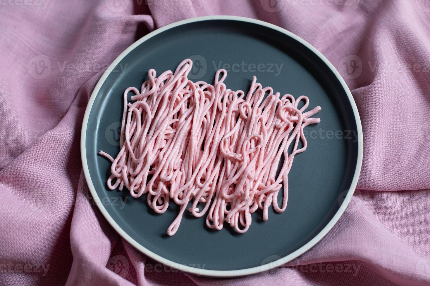 rosa tarama pasta på en grå tallrik pressas ut av en matlagning väska, kreativ textur foto