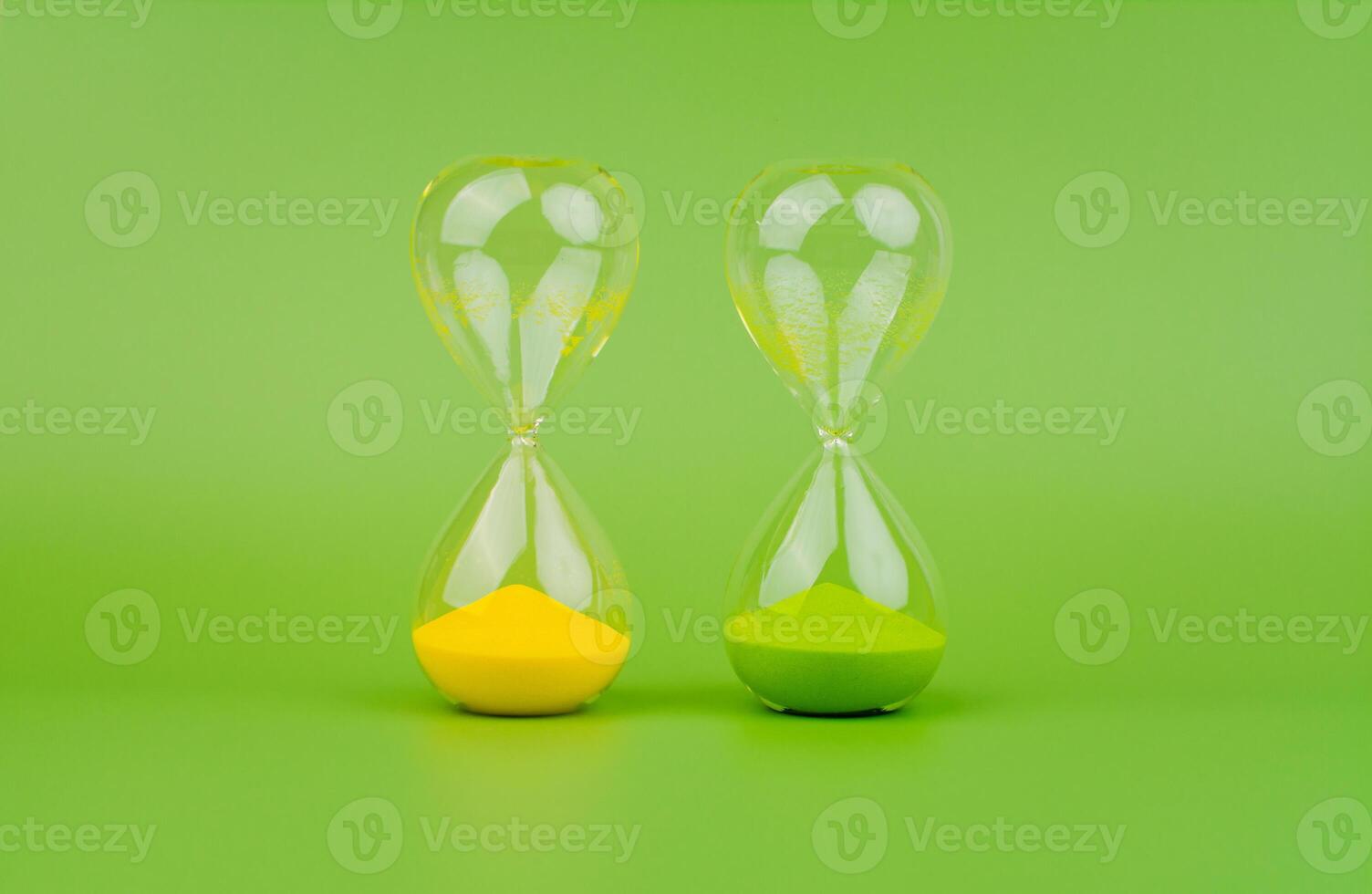 grön och gul timglas på en ljus grön bakgrund, regler av tid och nedräkning tid bearbeta. foto