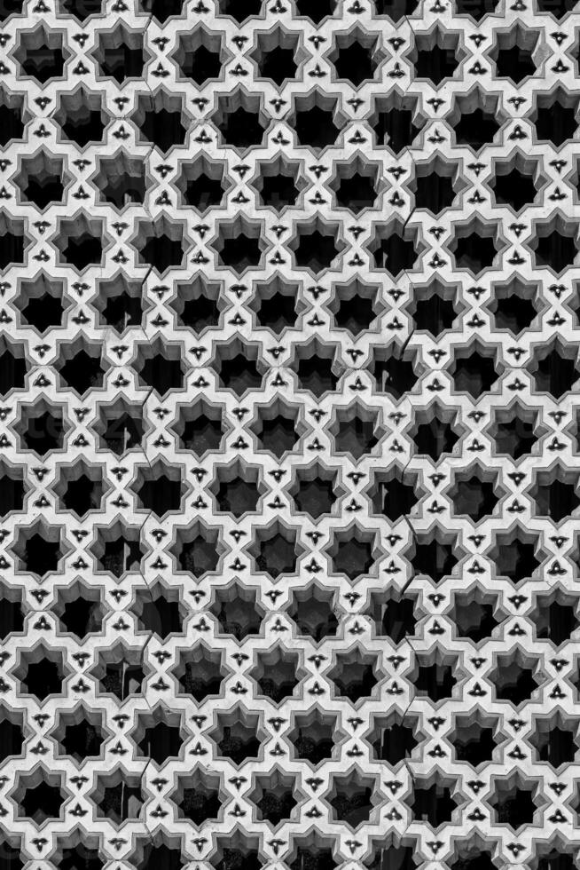 de fönster av en muslim moské Bakom barer i de form av en geometrisk hexagonal islamic prydnad. svart och vit. foto