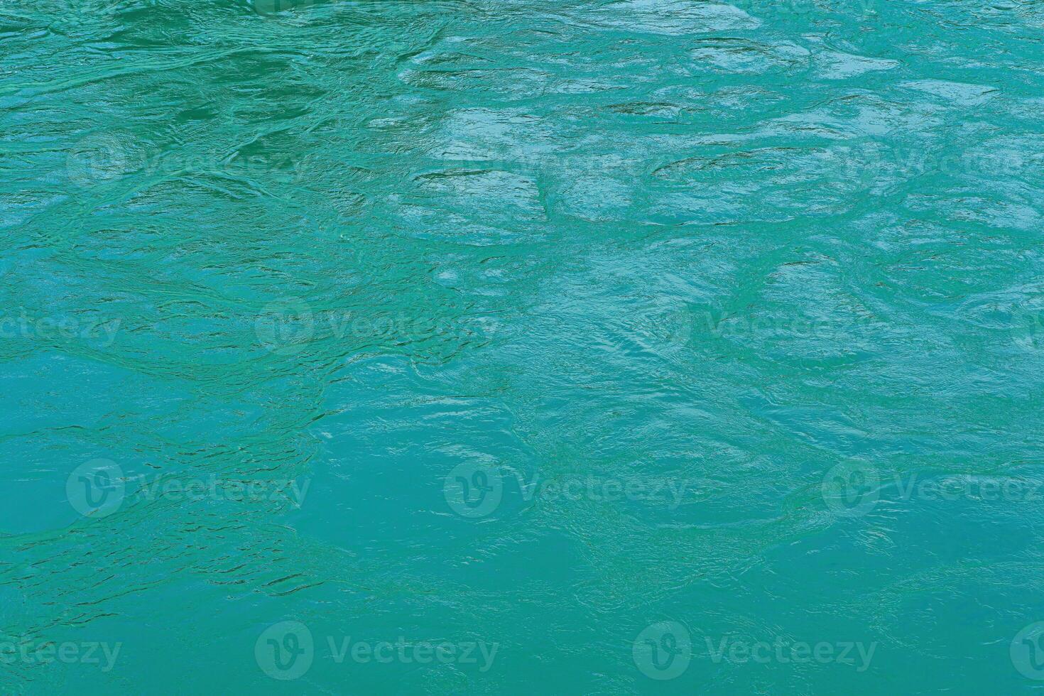 de textur av de vågor av turkos Färg av snabbt flytande vatten i de flod. foto