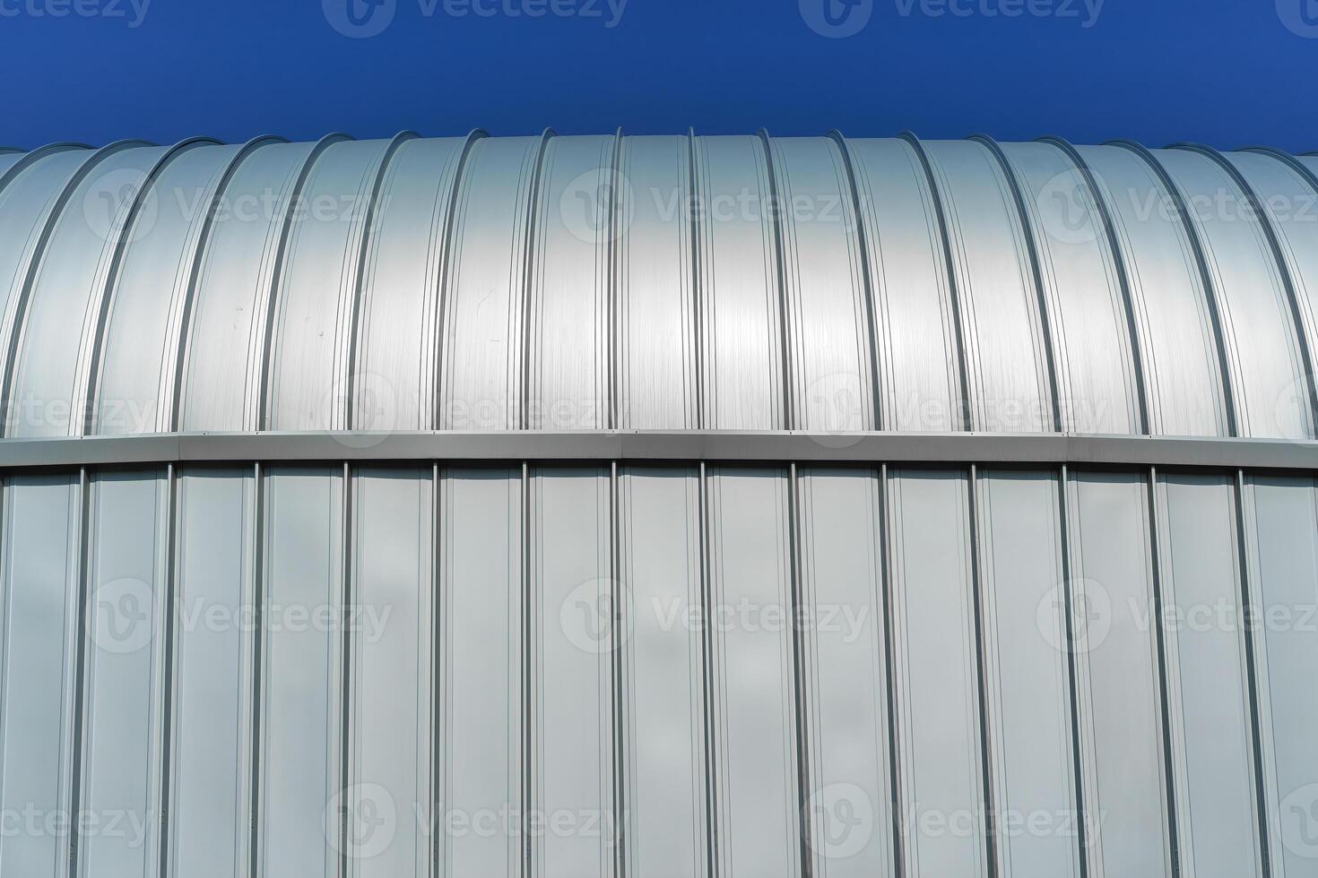 en modern byggnad täckt med metall aluminium paneler mot de blå himmel. foto