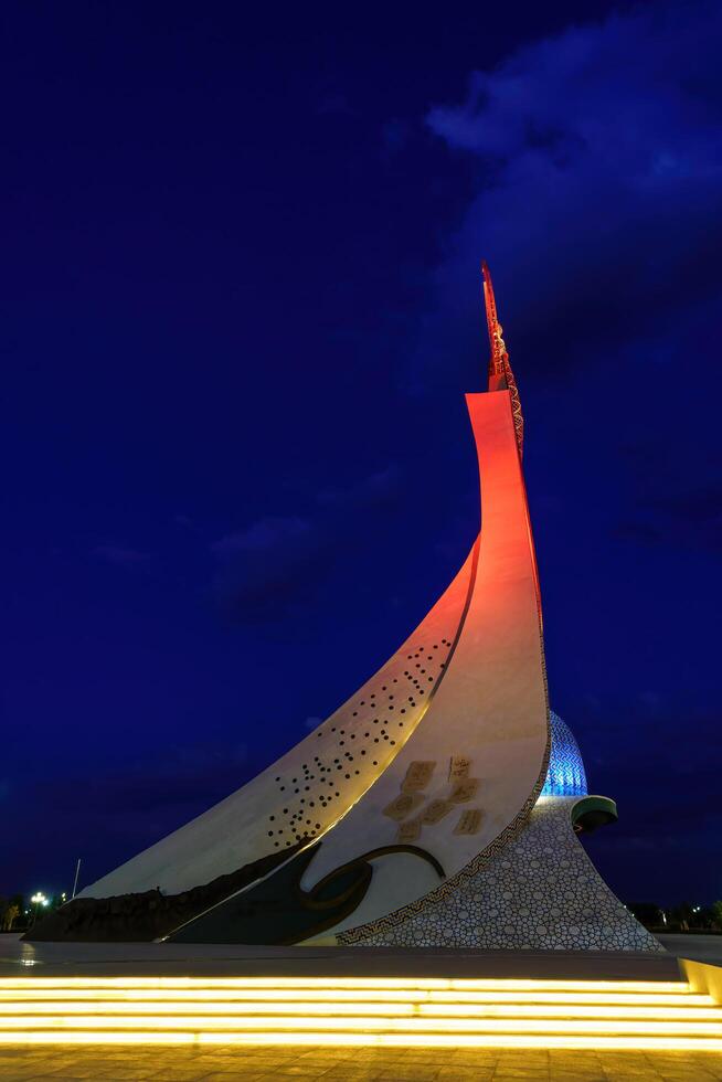 uzbekistan, Tasjkent - oktober 4, 2023 upplyst monument av oberoende i de form av en stele med en humo fågel i de ny uzbekistan parkera på nattetid i höst. foto