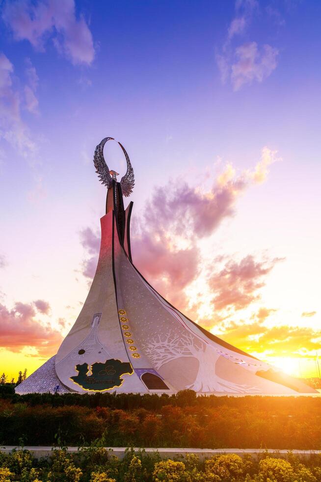 uzbekistan, Tasjkent - oktober 4, 2023 monument av oberoende i de form av en stele med en humo fågel på en skymning med cliody himmel i de ny uzbekistan parkera. foto