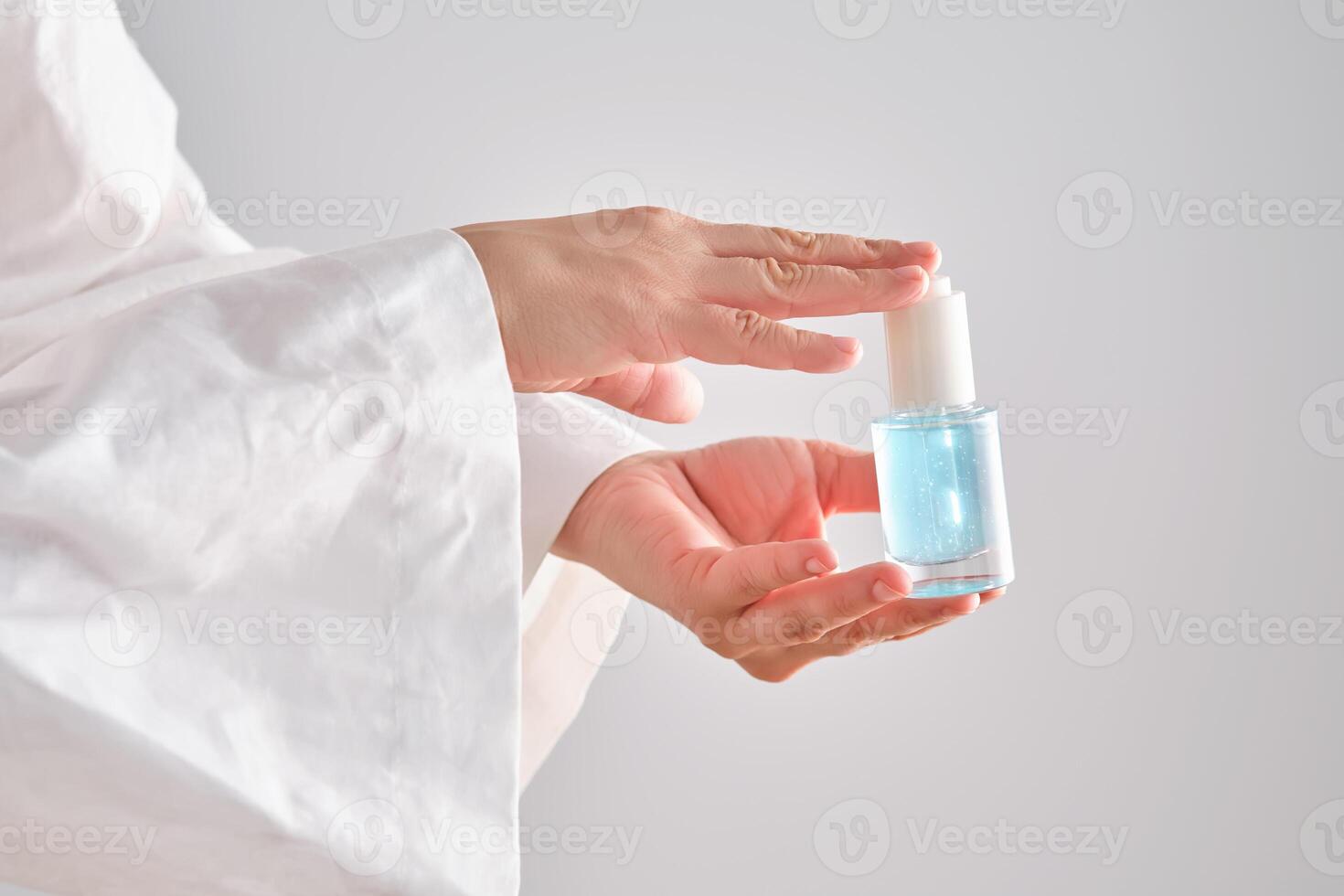 blå serum med pipett i en kvinnors händer i en morgonrock. foto