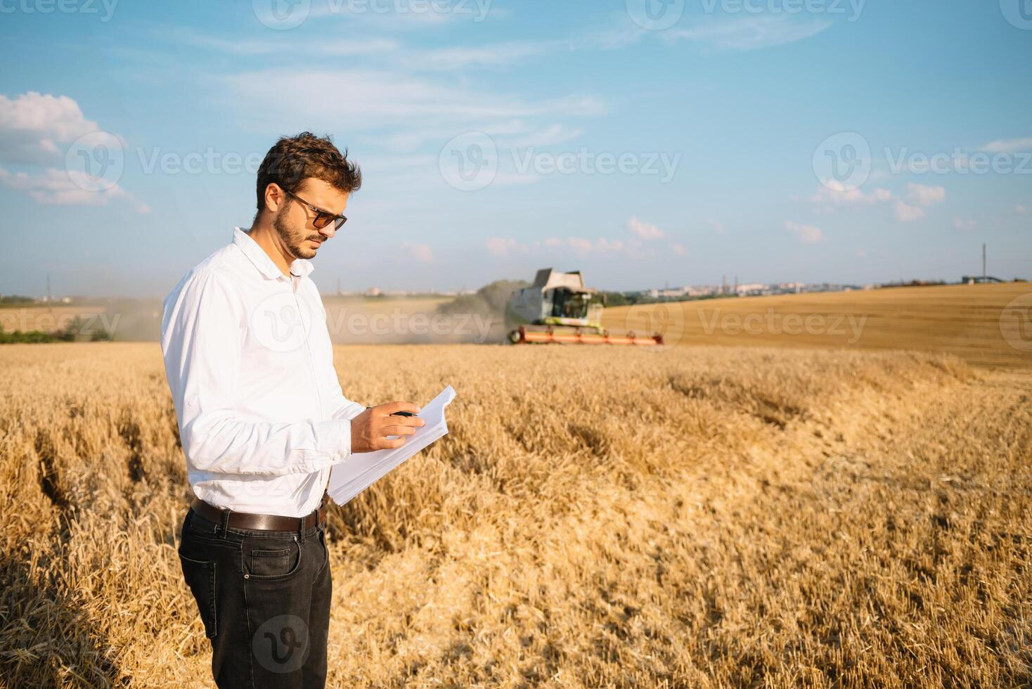 Lycklig jordbrukare i de fält kontroll majs växter under en solig sommar dag, lantbruk och mat produktion begrepp foto