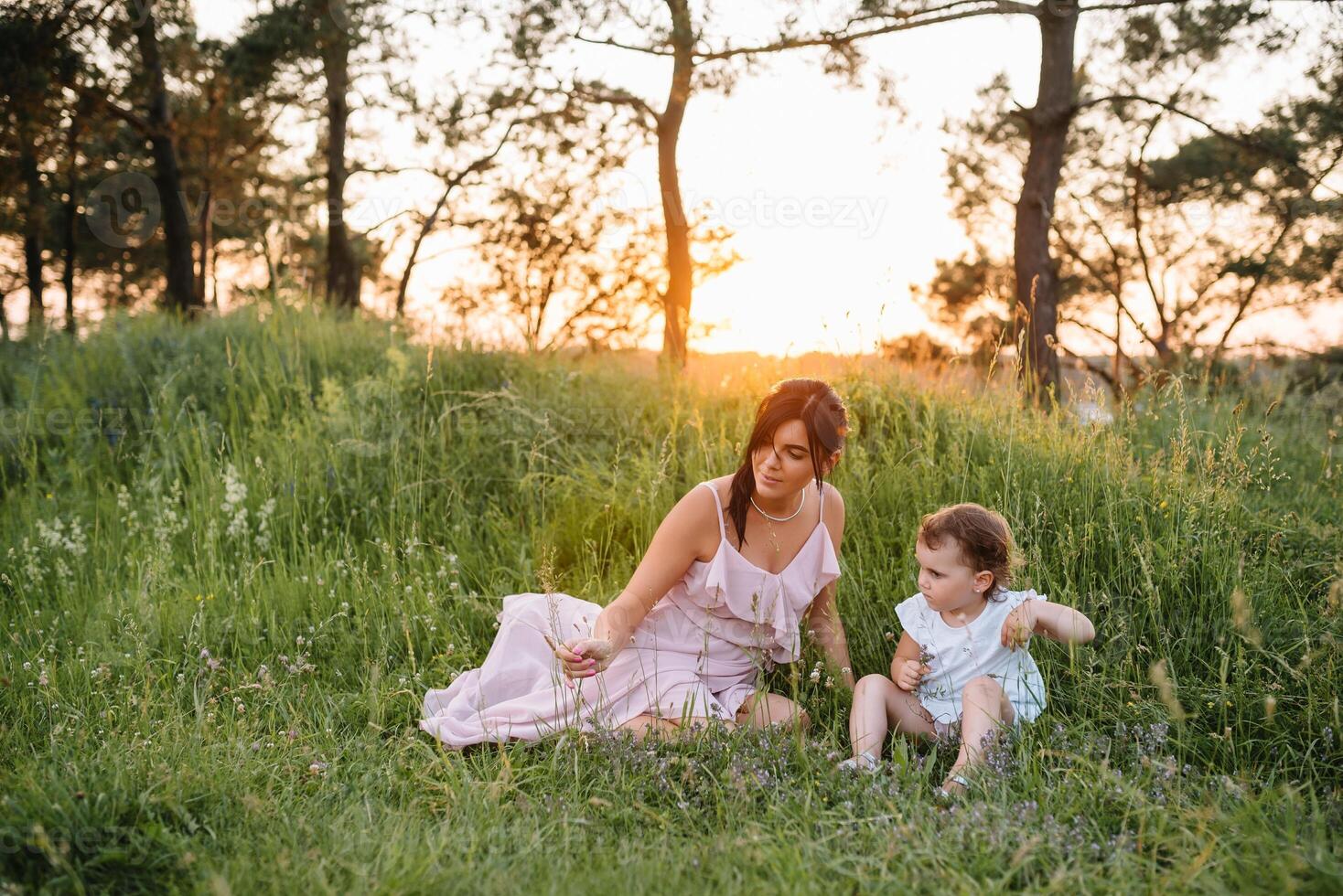 eleganta mor och stilig dotter har roligt på de natur. Lycklig familj begrepp. skönhet natur scen med familj utomhus- livsstil. familj vilar tillsammans. lycka i familj liv. mödrar dag. foto