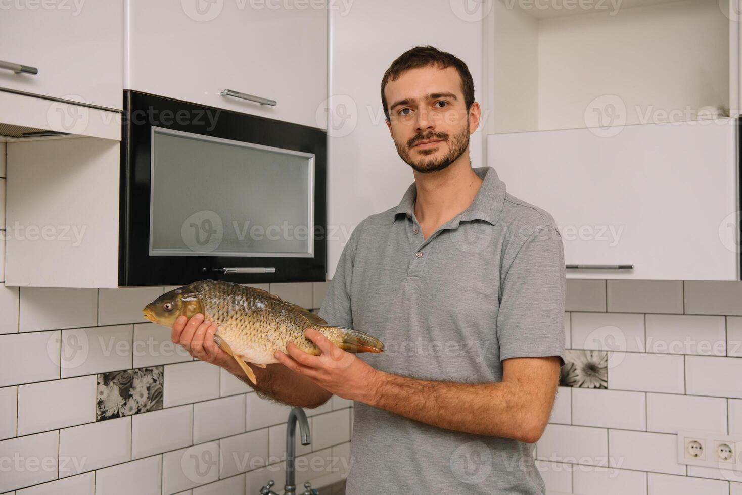 man skärande färsk fisk i kök i Hem. man slakt fisk för laga mat. foto