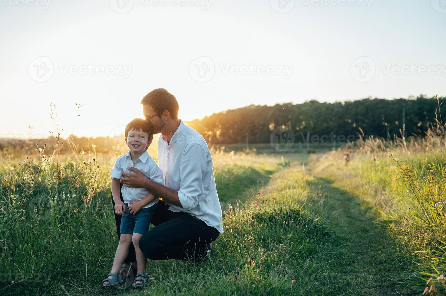 stilig pappa med hans liten söt son är har roligt och spelar på grön gräs- gräsmatta. Lycklig familj begrepp. skönhet natur scen med familj utomhus- livsstil. familj vilar tillsammans. fäder dag. foto