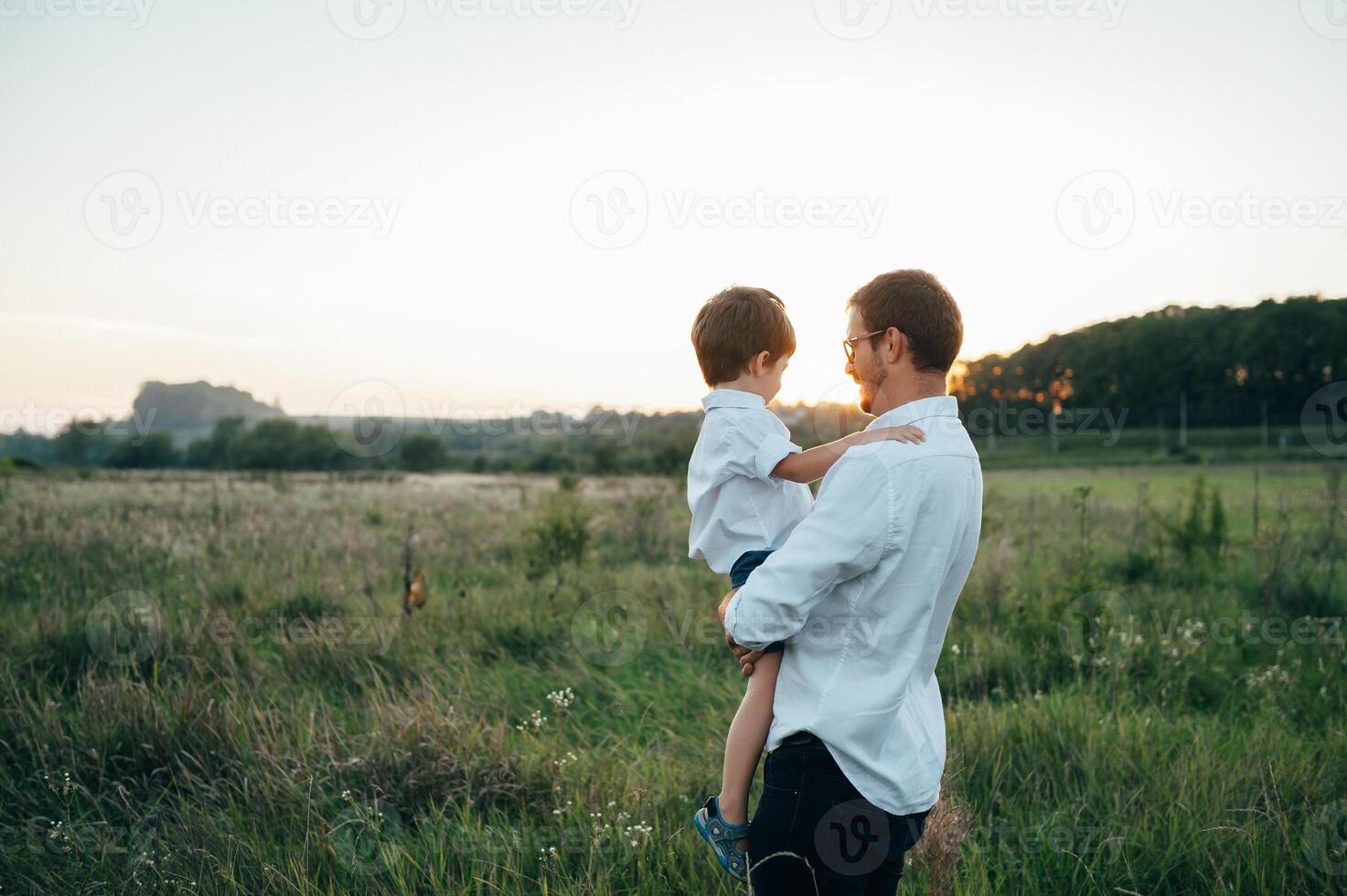 stilig pappa med hans liten söt son är har roligt och spelar på grön gräs- gräsmatta. Lycklig familj begrepp. skönhet natur scen med familj utomhus- livsstil. familj vilar tillsammans. fäder dag. foto