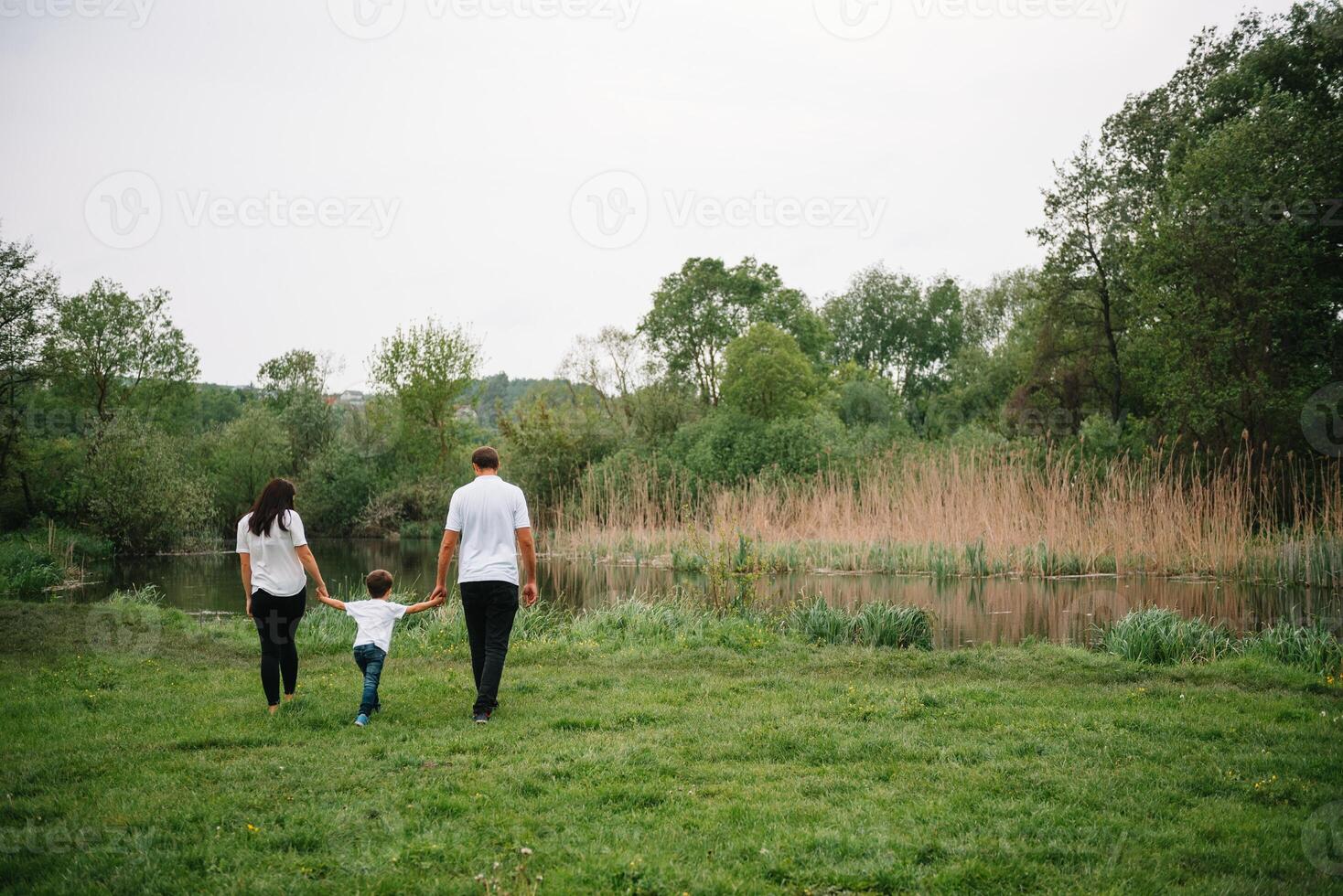 Lycklig familj mor far och barn son på natur på solnedgång. mamma, pappa och unge skrattande och kramar, njuter natur utanför. solig dag, Bra humör. begrepp av en Lycklig familj. foto