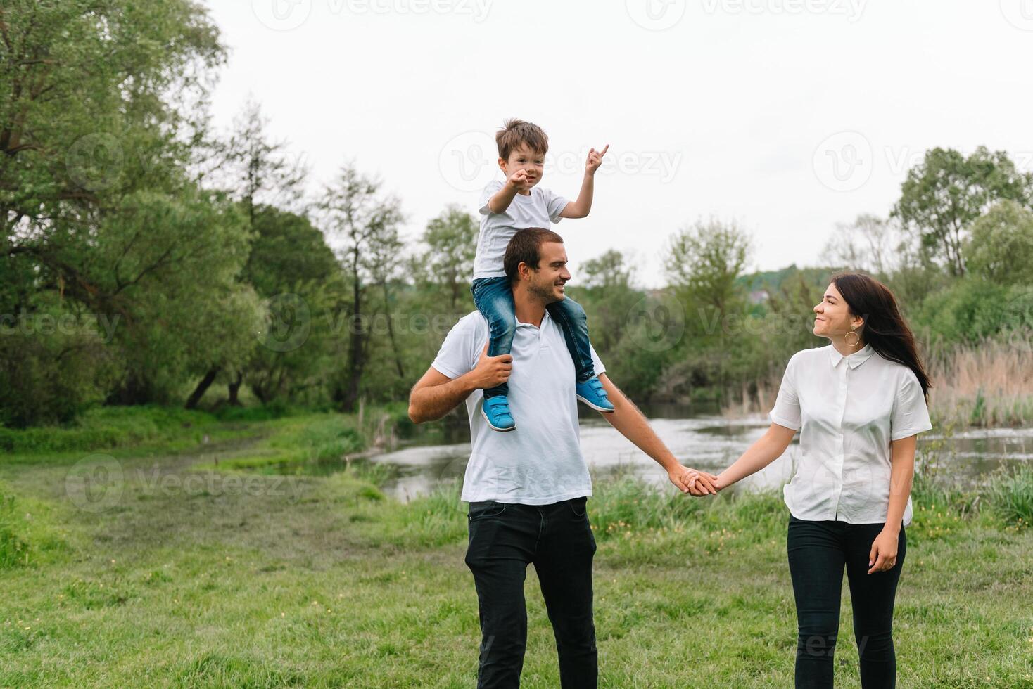 Lycklig familj mor far och barn son på natur på solnedgång. mamma, pappa och unge skrattande och kramar, njuter natur utanför. solig dag, Bra humör. begrepp av en Lycklig familj. foto