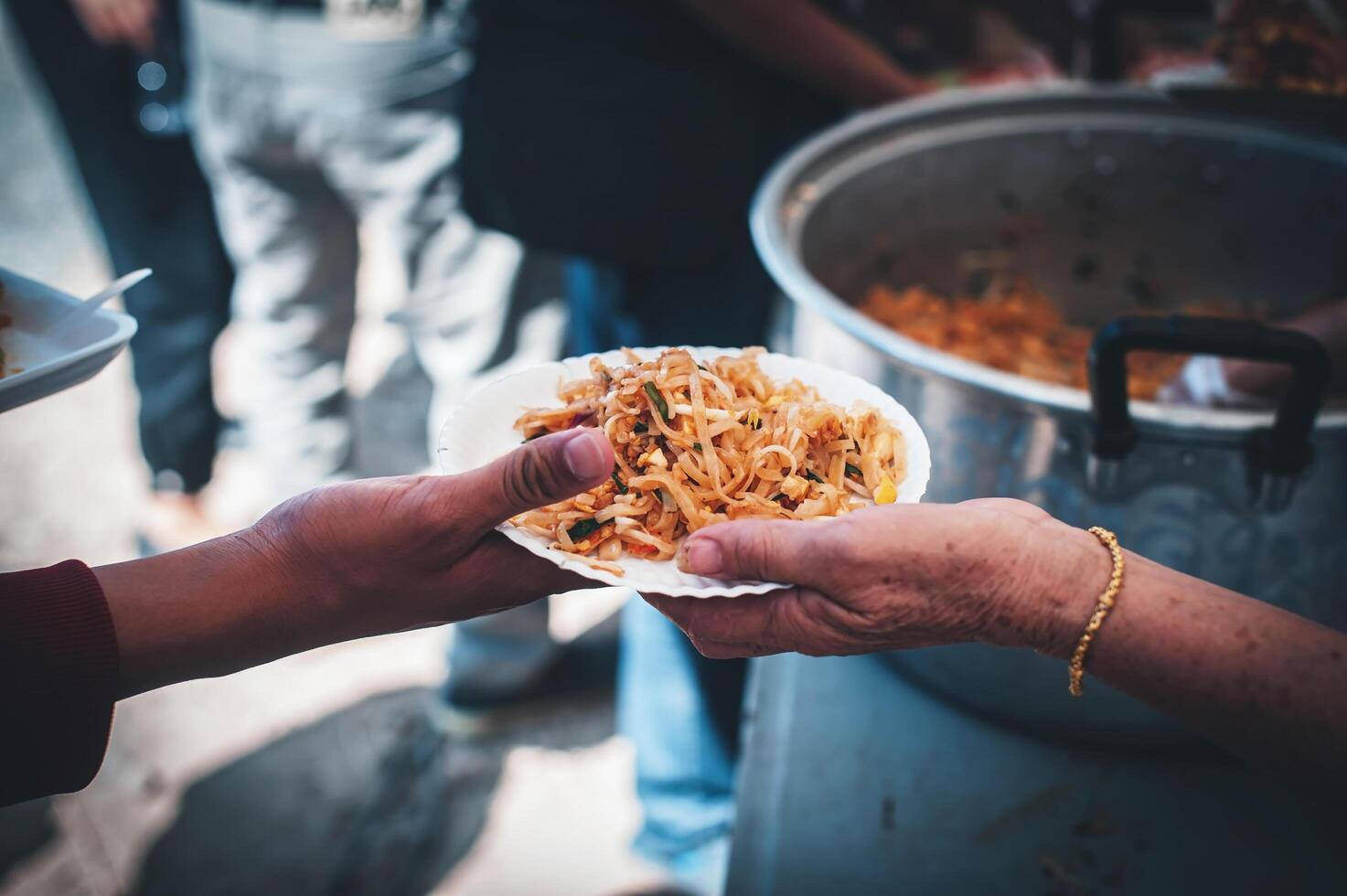 volontärer tjänande varm måltider till hungrig migranter humanitär hjälpa begrepp. foto