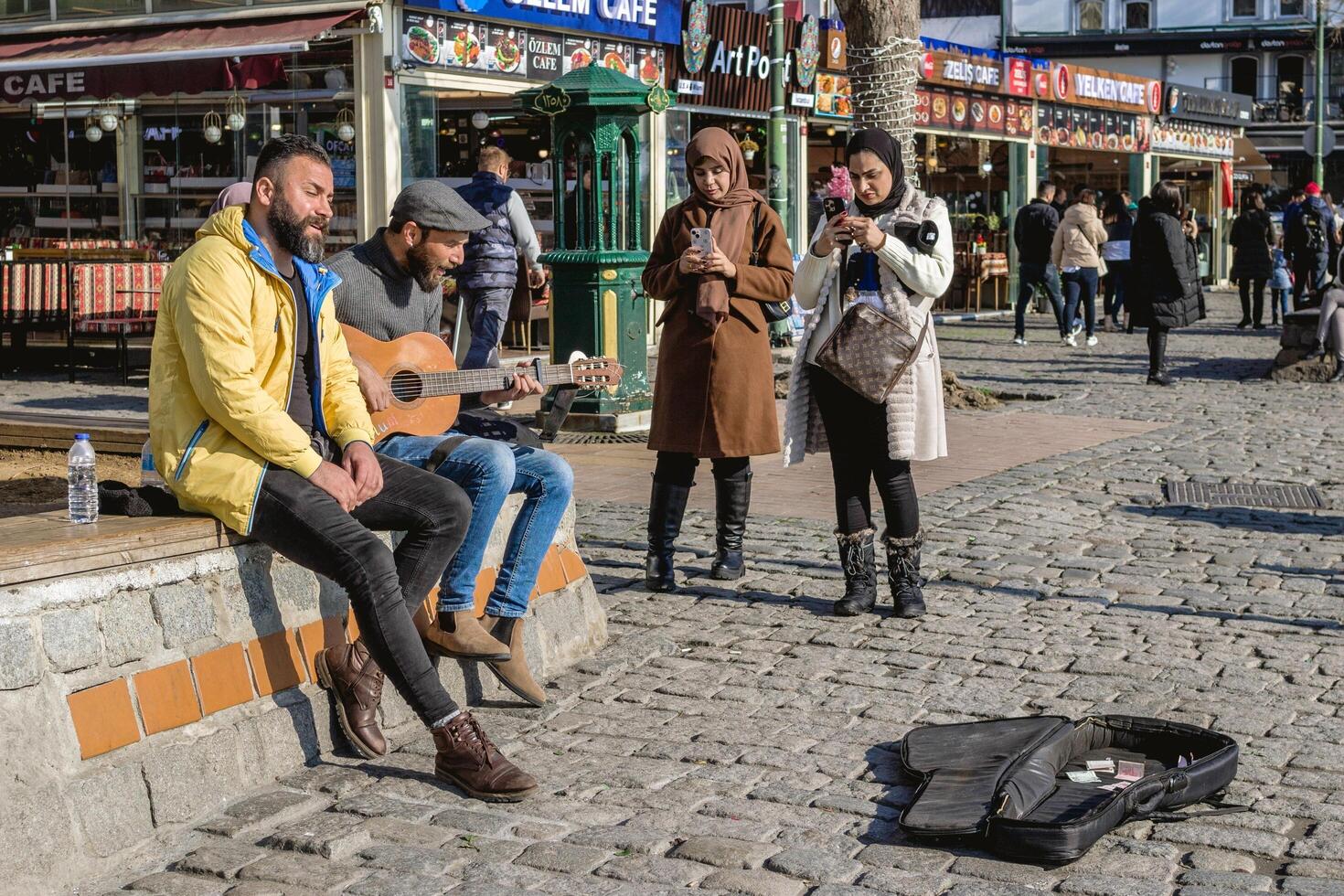 istanbul, Kalkon - december 29, 2022. gata musiker spelar gitarr för turister på en kullersten gata. foto