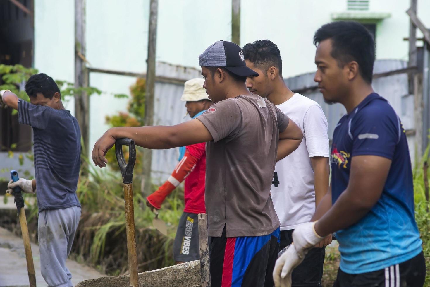 västra papua, indonesien, 11-7-21 bybor reparerar skadade gångvägar foto