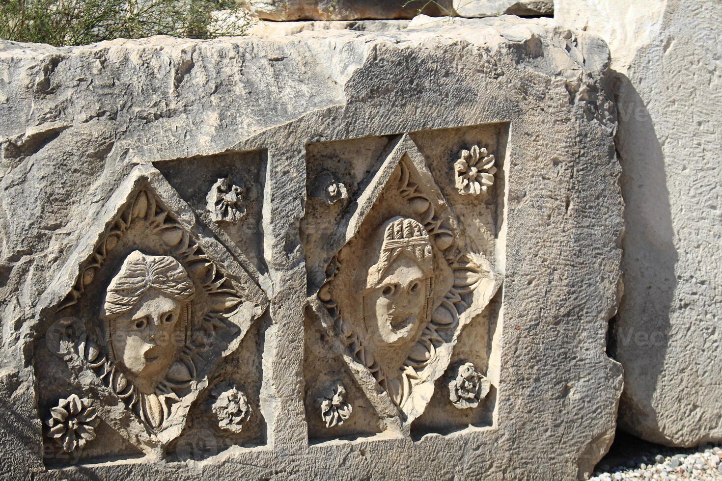 historisk sten relief med ristade ansikten i gammal stad av myra på solig dag. död- civilisation. ruiner av sten gravar i Lycia område, demre, antalya, turkiye foto