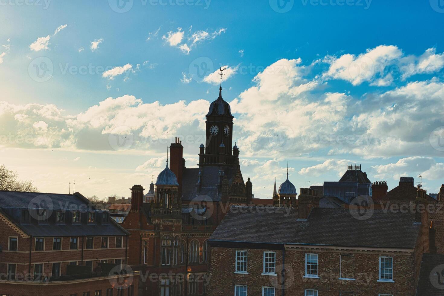 årgång europeisk arkitektur med en klocka torn mot en bakgrund av en dramatisk himmel med fluffig moln, fångande de väsen av en historisk stad på solnedgång i york, norr yorkshire, england. foto