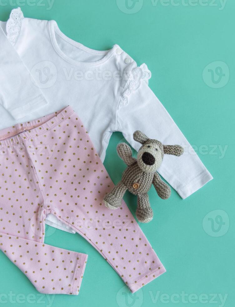 uppsättning av bebis bodys, byxor, strumpor och stickat leksak foto