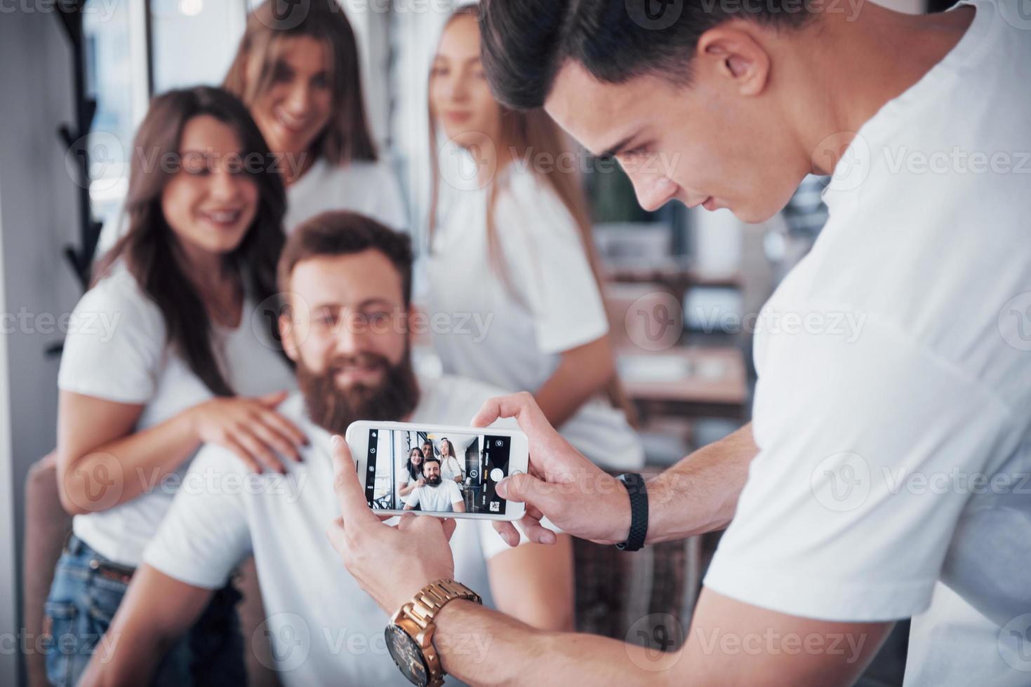 oskärpa porträtt av lyckliga unga bästa vänner med händer som håller telefonen på förgrunden foto